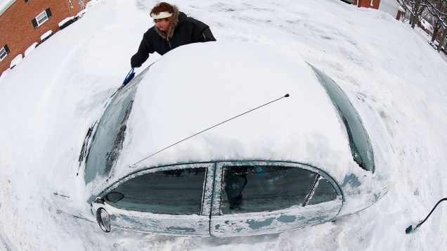 <p>Mulher remove a neve que cobriu seu carro, em Grosse Pointe, Michigan</p>