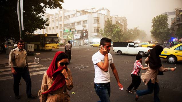 Pessoas andam pelas ruas de Teerã, capital do Irã, em meio a uma tempestade de areia