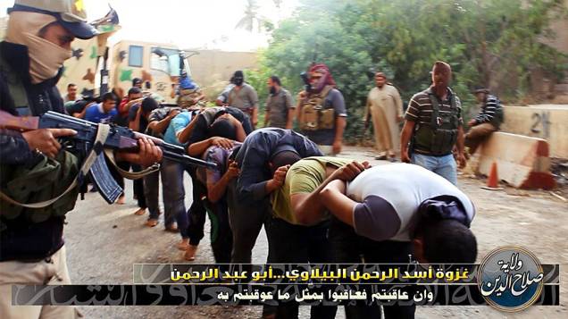 Imagem divulgada pelo site jihadista Welayat Salahuddin mostra militantes do Estado Islâmico do Iraque e do Levante (EIIL) ao lado de dezenas de iraquianos membros das forças de segurança antes de serem executados em um local desconhecido<br><br> 
