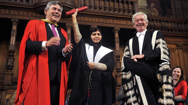 Malala Yousafzai recebe das mãos do ex-primeiro-ministro britânico Gordon Brown e do professor Timothy OShea, o título de mestrado honorário da Universidade de Edimburgo durante a primeira reunião da Comissão de Cidadania global da universidade, na Escócia
