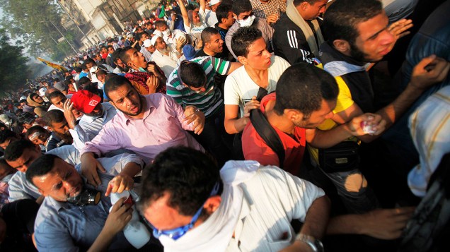 Membros da Irmandade Muçulmana e simpatizantes do deposto presidente egípcio, Mohamed Mursi recebem bomba de gás lacrimogêneo lançado pela polícia durante os confrontos ao longo de uma estrada em Kornish El Nile, que leva à praça Tahrir (06/10/2013)