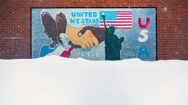 <p> Uma grande quantidade de neve cobriu parcialmente o muro de uma escola no centro de Manhattan, em Nova York </p>