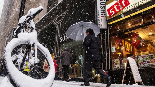 <p>Pedestres caminham pela neve durante a manhã no distrito financeiro de Nova York, perto de Wall Street</p>
