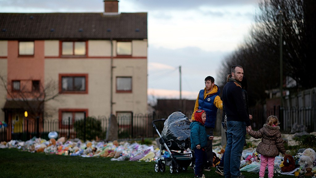 Pessoas depositam flores e velas perto da casa de Mikaeel Kular, 3, desaparecido, em Kirkcaldy, na Escócia