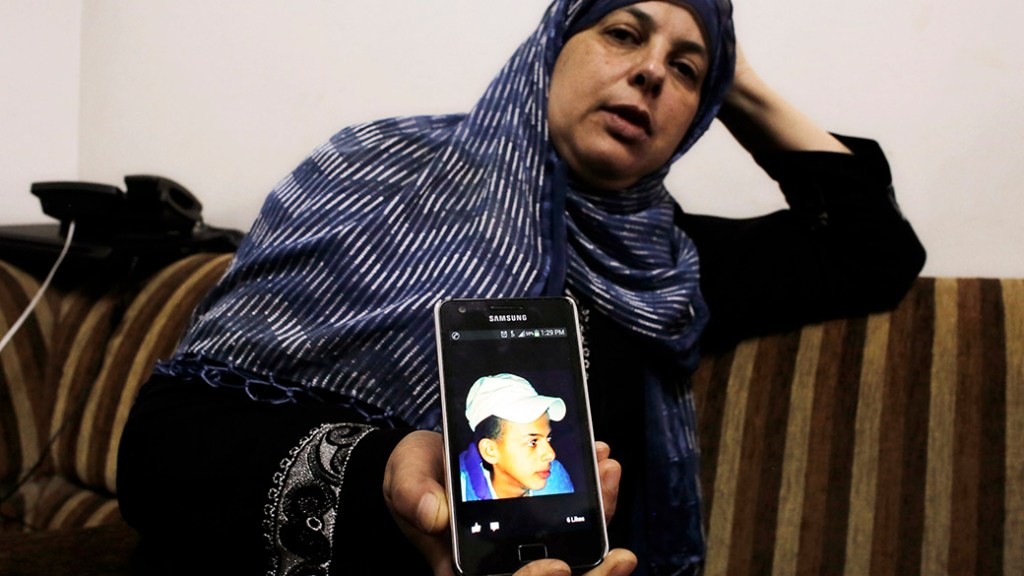 Mãe do menino Mohammed Abu Khudair mostra a foto no celular do filho, em Jerusalém