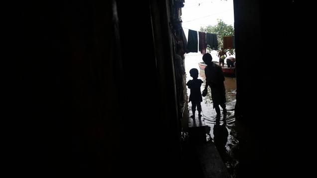 Crianças observam a cheia do rio Yamuna após as fortes chuvas de monção em Nova Délhi, na Índia