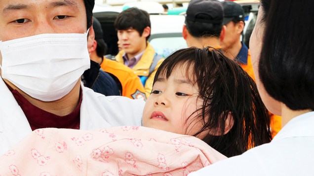 Menina é resgatada do navio Sewol que transportava cerca de 470 pessoas e naufragou na Coreia do Sul