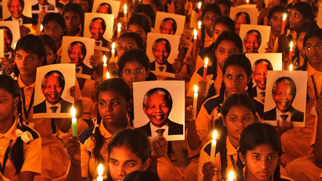 Alunos seguram velas e retratos de ex-Presidente sul-Africano Nelson Mandela durante uma cerimônia de oração, em uma escola na cidade de Chennai, na Índia