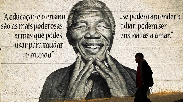 Homem passa por um mural com a imagem do ex-presidente sul-africano Nelson Mandela, em Loures, nos arredores de Lisboa, Portugal