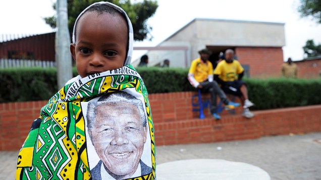 Criança envolta em um pano com a imagem do ex-presidente sul-africano Nelson Mandela é vista em Soweto, na África do Sul