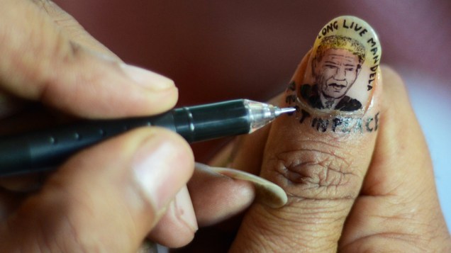 Artista desenha um retrato do ex-presidente Sul-Africano Nelson Mandela em uma unha, como parte de sua homenagem em Siliguri, na Índia