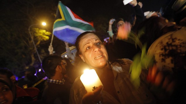 Sul-africanos acendem velas em frente à casa de Nelson Mandela em Johannesburgo, para homenagear o ex-presidente, morto nesta quinta-feira (05), aos 95 anos