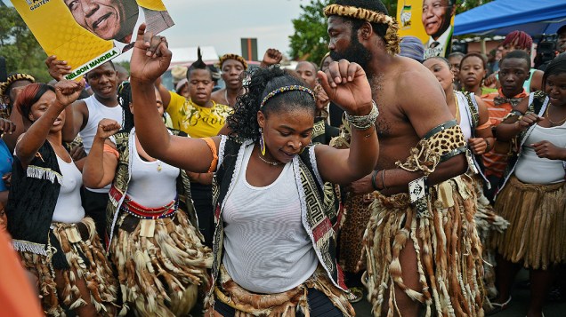Sul-africanos dançam com roupas tradicionais durante uma cerimônia em homenagem ao ex-presidente Nelson Mandela em Orlando West, distrito de Johannesburgo