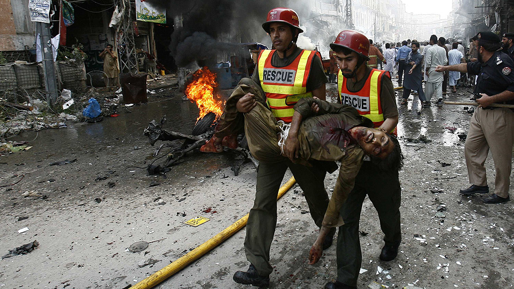 Equipes trabalham em área que sofreu atentado, no Paquistão