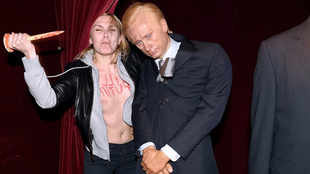Uma ativista do grupo feminista Femen destrói uma estátua de cera do presidente russo, Vladimir Putin, no Museu Grévin em Paris