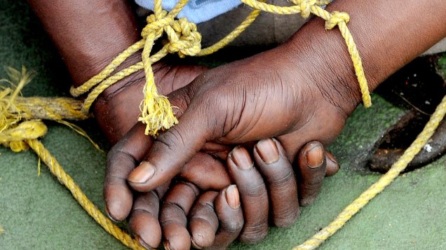 Pirata da Somália com as mão amarradas em um navio da guarda costeira indiana, após serem trazidos para Mumbai