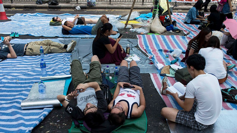 Manifestantes pró-democracia deitam em esteiras em baixo de tendas improvisadas no meio da rua, em Hong Kong