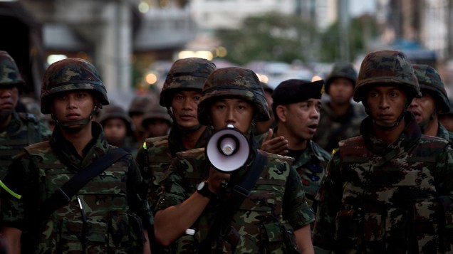 Soldados do exército tailandês incitam os manifestantes anti-golpe de manter a lei e a ordem durante um protesto no centro de Bangcoc 