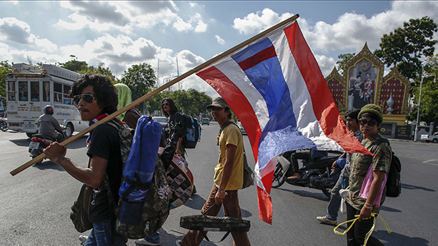 Um dia após o golpe militar que instaurou uma ditadura no país, manifestantes anti-governo carregam bandeiras por diversas cidades da Tailândia