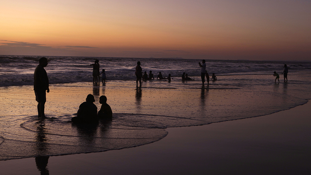 Pessoas são fotografadas durante o pôr-do-sol, na praia de Baga, na região de Goa, Índia