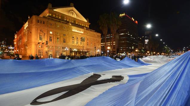Bandeira gigante da Argentina com símbolo de luto é levada por manifestantes