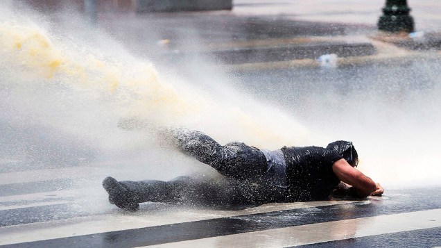 Manifestante é arremessado por canhões de água da polícia durante uma manifestação na praça Kizilay no centro de Ancara. A polícia disparou gás lacrimogêneo e canhões de água e retiraram os manifestante da praça depois de duas semanas de protestos anti-governo
