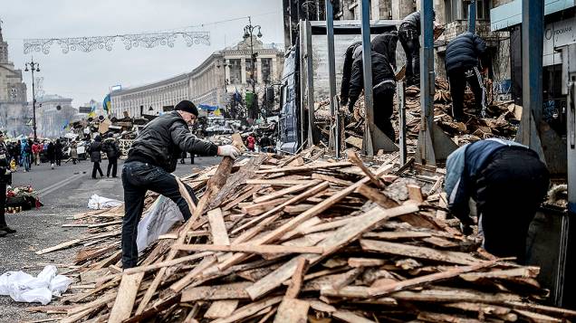 Pessoas recolhem madeiras na Praça da Independência em Kiev, na Ucrânia
