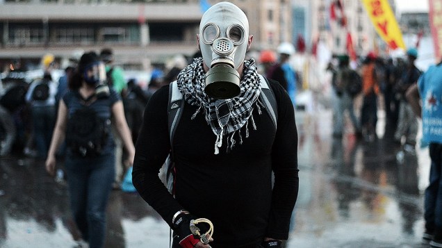 Manifestante usa máscara de gás durante confrontos com a polícia na praça Taksim, em Istambul