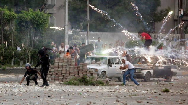 Fogos de artifício é lançado contra a polícia e manifestantes anti-Mursi na cidade de Nasr, no Egito