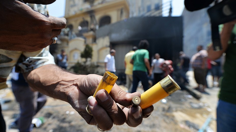 Egípcio mostra cartuchos de munição do lado de fora da sede incendiada, do partido da Irmandade Muçulmana no distrito Moqattam do Cairo, na segunda-feira 1º de julho