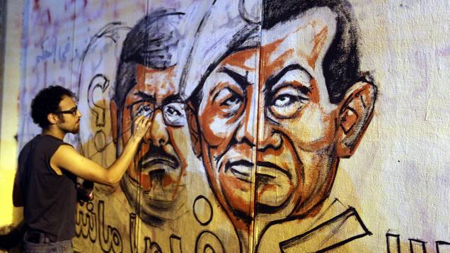 Manifestante faz um grafite com o rosto do presidente do Egito, Mohamed Mursi, pedindo sua renúncia, nesta segunda-feira (01/07/2013)