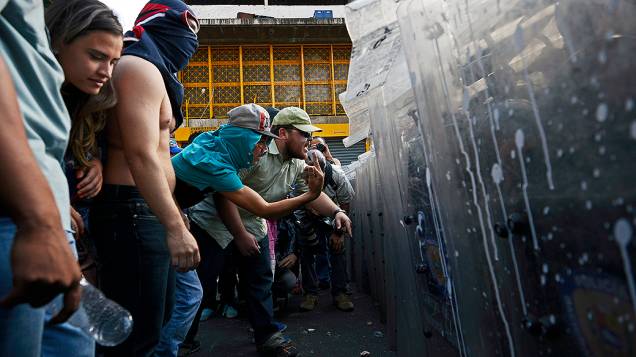Manifestantes enfrentam a polícia durante protestos da oposição contra o governo do presidente venezuelano, Nicolás Maduro, em Caracas