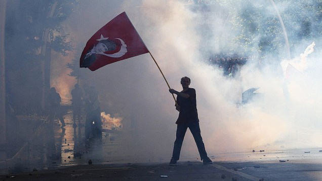 Manifestante segura uma bandeira turca com um retrato de Mustafa Kemal Ataturk, durante protestos em Ancara