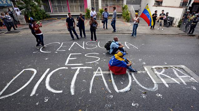 Estudantes sentam na rua sobre a frase A censura é ditadura, durante um protesto anti-governo em Caracas - (17/02/2014)