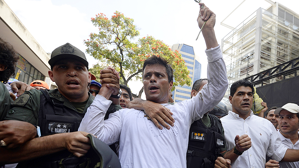 Leopoldo López, um dos líderes da oposição ao governo de Nicolás Maduro, é escoltado pela Guarda Nacional depois de se entregar, durante uma manifestação em Caracas