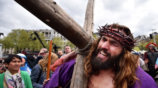 Ator carrega uma cruz durante encenação da Paixão de Cristo na Sexta-feira Santa, em Londres