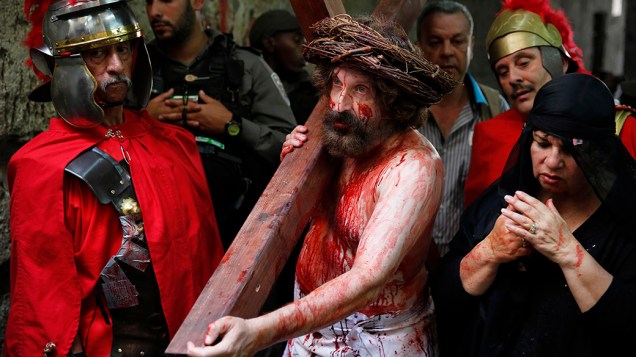 Homem carrega um cruz durante procissão da Sexta-feira Santa, em Jersusalém