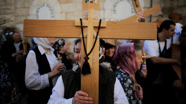Devota segura uma cruz durante procissão da Sexta-feira Santa, em Jerusalém