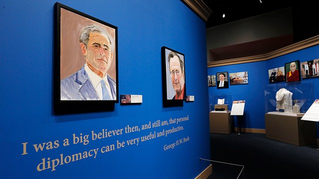 Auto-retrato do ex-presidente George W. Bush e de seu pai, o também ex-presidente dos EUA George H.W. Bush, saúdam os visitantes na entrada da exposição "A Arte da Liderança: Diplomacia Pessoal de um Presidente" na Biblioteca e Museu Presidencial Bush, em Dallas, no Texas