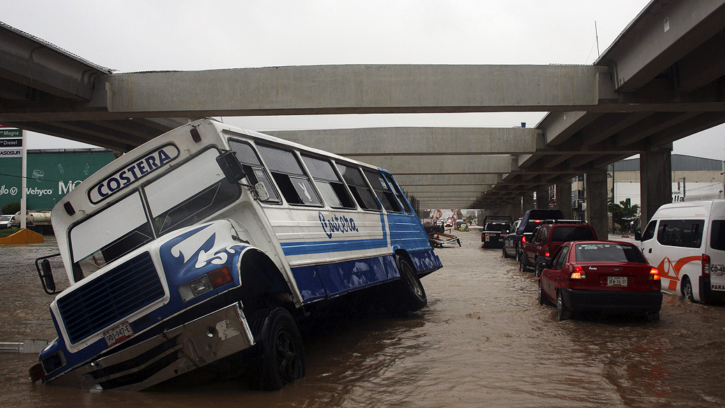Ônibus e carros em rua inundada de Aculpo, no México, que sofreu os estragos de um ciclone