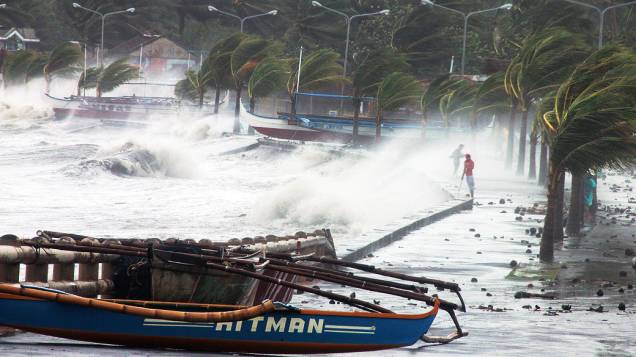 Moradores passam por chuva e ventos fortes, após tufão Haiyan atingir a cidade de Legaspi, ao sul de Manila, nas Filipinas