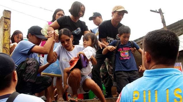 Moradores que vivem perto das encostas do vulcão Mayon são evacuados por causa do tufão Haiyan ter atingido a  província de Albay na região central das Filipinas