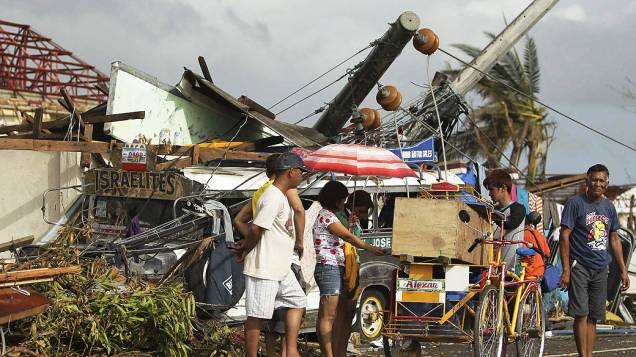 Pessoas passam por destroços causados pelo tufão Haiyan, na cidade de Tacloban, nas Filipinas