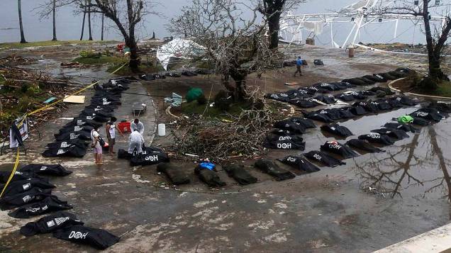 Pessoas observam fila de corpos de vítimas do supertufão Haiyan em Tacloban, nas Filipinas
