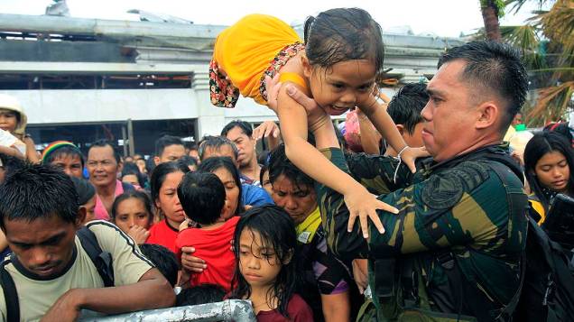 Soldado retira crianças durante a evacuação da cidade de Tacloban