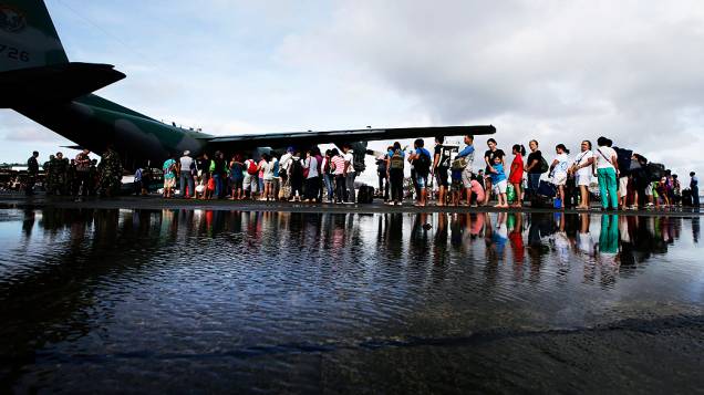 Sobreviventes do tufão Haiyan esperam para embarcar, nesta quarta-feira (13/11), no aeroporto de Tacloban