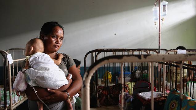 Mulher segura um bebê recém-nascido em uma maternidade em Leyte, nas Filipinas