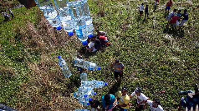 Um helicóptero militar distribui garrafas de água para os sobreviventes do supertufão Haiyan em Tolosa, Leyte, no centro das Filipinas