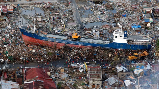 Moradores observam um navio que foi arrastado pelo tufão Haiyan para o centro da cidade de Tacloban, nas Filipinas