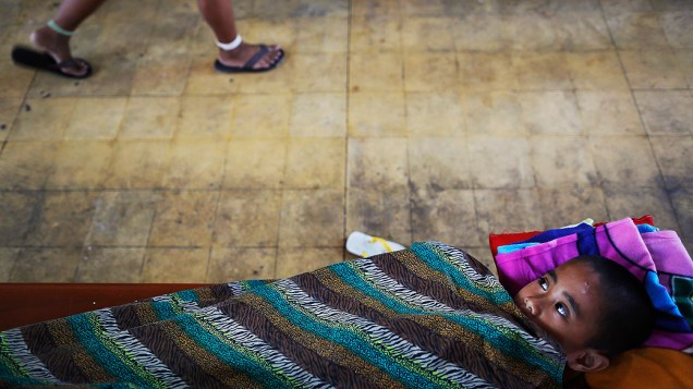 Criança deitada em uma igreja, que se tornou um abrigo improvisado para acolher centenas de sobreviventes do tufão Haiyan em Tacloban